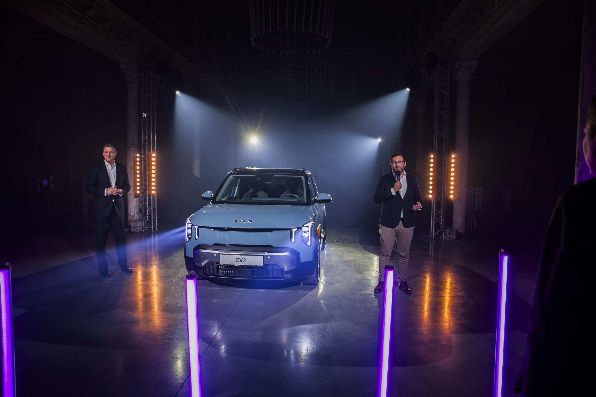 Eine Gruppe von Männern steht vor einem Auto.