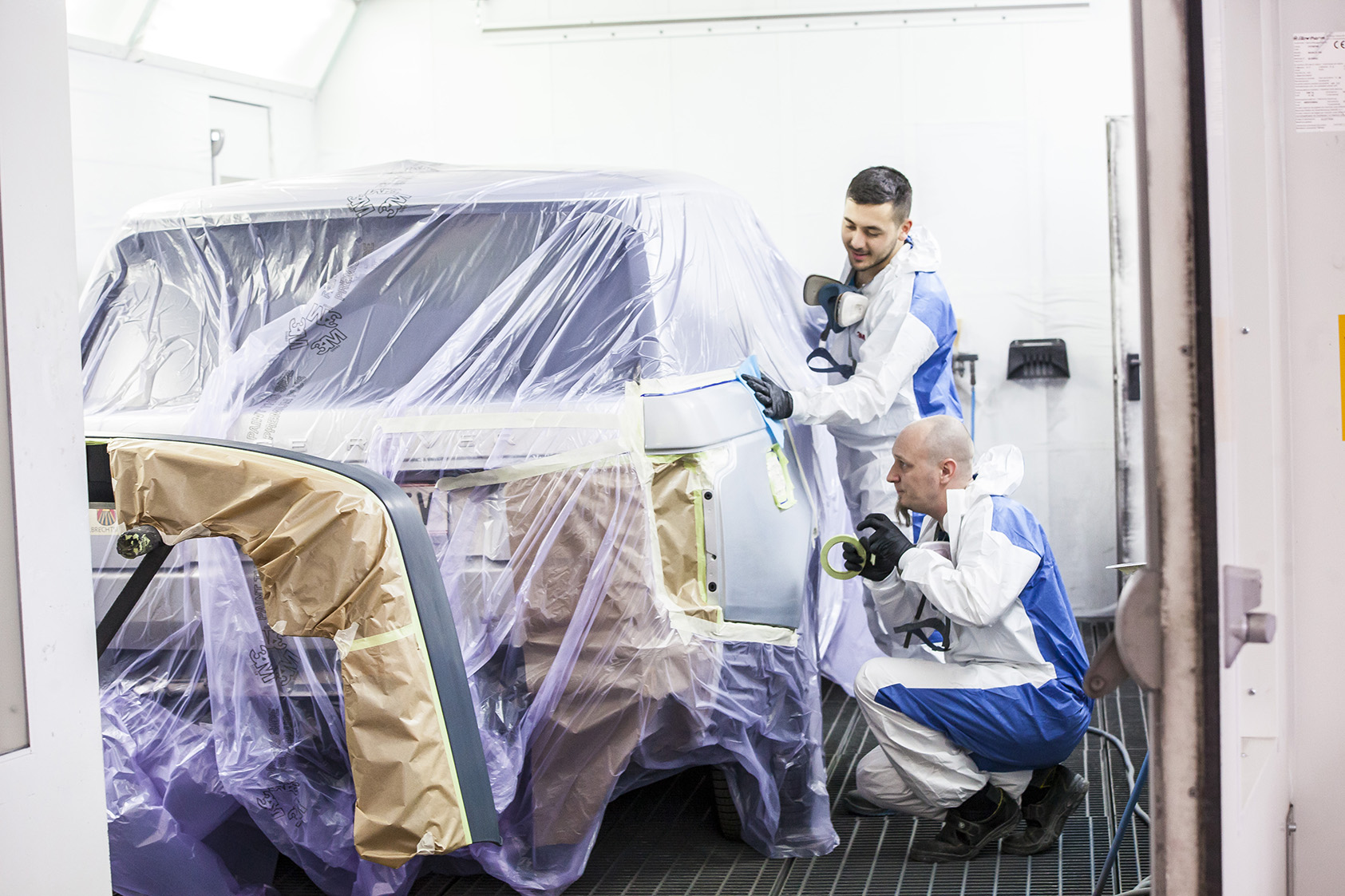 Team AUTO STAHL Wien 20 Lackierkabine Lackierarbeiten an einem Fahrzeug, Seitenansicht gemeinsames Arbeiten