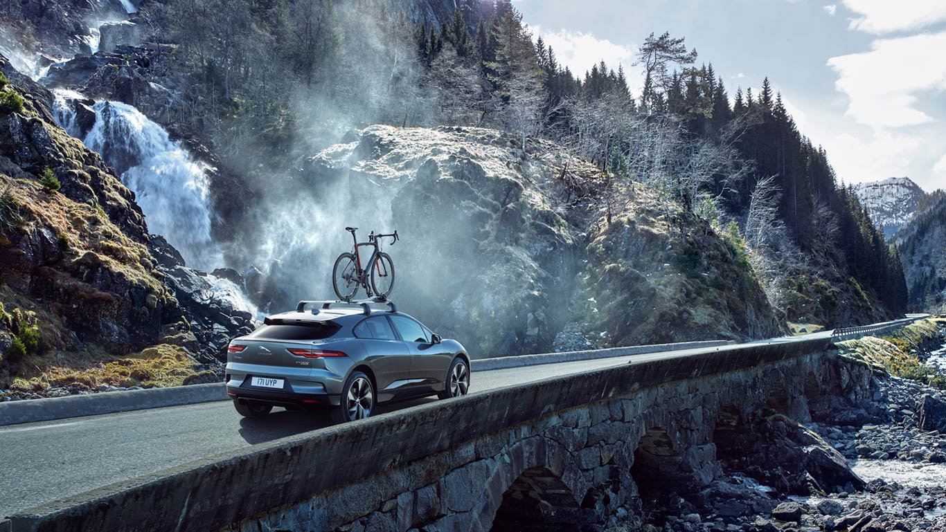 Jaguar I-Pace bei Auto Stahl Grau Seitenansicht Heckansicht Dachträger Berge