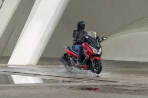 Honda Forza 125 bei Auto Stahl Seitenansicht Rot Schwarz Wasser