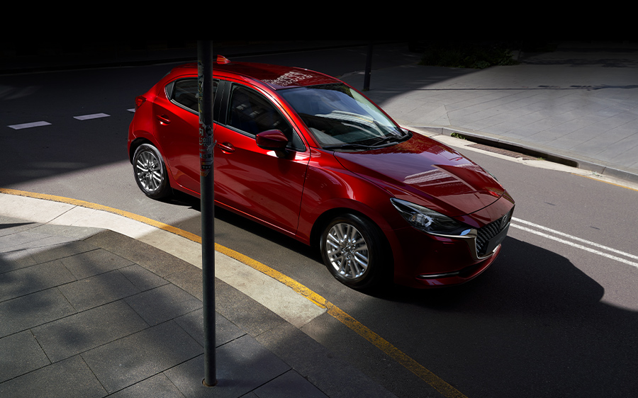Mazda 2 bei Auto Stahl Modellabbildung in der Modellfarbe rot in schräge Frontansicht