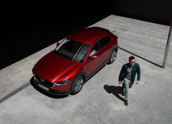 Mazda CX-30 bei Auto Stahl Modellabbildung, Außenansicht mit modernem Fahrer, Wagenfarbe rot